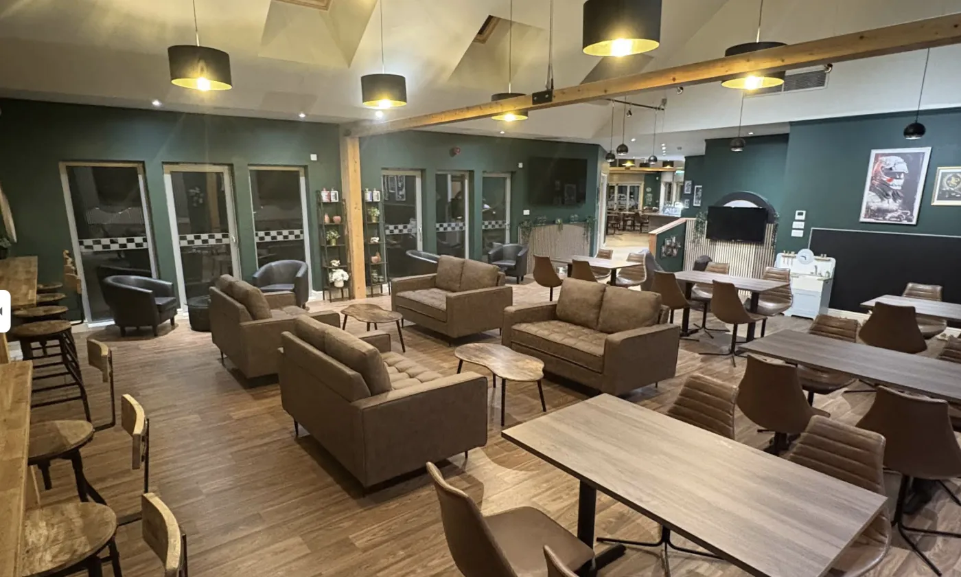 The motorsport lounge at The Drive at Haddo café, Aberdeenshire, with sofas and big screens